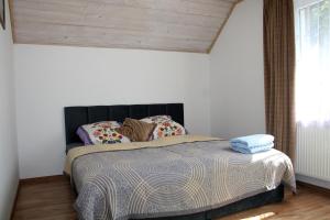 a bed with a black headboard in a bedroom at Dom w Bieszczadach 10 osobowy in Wołkowyja