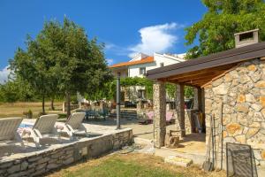 a patio with chairs and a stone wall at My Dalmatia - Villa Mandorla with private pool and Jacuzzi in Zadar