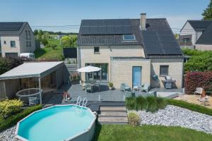 a backyard with a swimming pool and a house at Gîte d'Anpa in Ohey