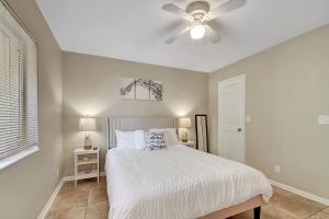 a bedroom with a white bed and a ceiling fan at 2 BR Home Close to The Beach in Lantana