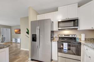 a kitchen with stainless steel appliances and white cabinets at 2 BR Home Close to The Beach in Lantana