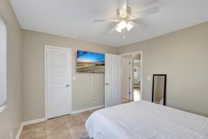 a bedroom with a white bed and a ceiling fan at 2 BR Home Close to The Beach in Lantana