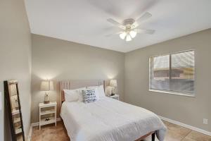 a white bedroom with a bed and a ceiling fan at 2 BR Home Close to The Beach in Lantana