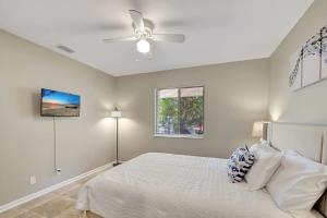 a white bedroom with a bed and a ceiling fan at 2 BR Home Close to The Beach in Lantana +28 photos