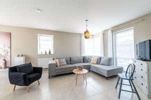 a living room with a couch and chairs and a tv at Gîte d'Anpa in Ohey
