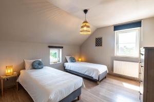 a bedroom with two beds and a pendant light at Gîte d'Anpa in Ohey +11 photos