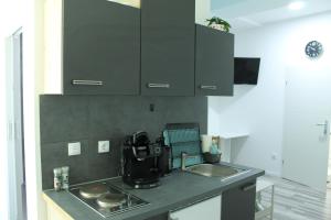 a kitchen with black cabinets and a sink at Royal Racing Suite Top 2 near Red Bull Ring in Judenburg +4 photos