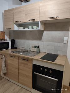 a kitchen with a sink and a stove at L'appartement à la ferme in Béthune