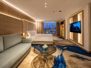 a hotel room with a bed and a couch and a tv at Flamingo Cairo Airport Hotel & Free Airport Pickup in Cairo +176 photos