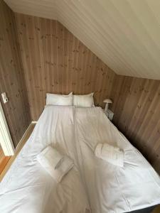 a bed with white sheets and pillows in a room at Finnvika Panorama Corner in Vestvågøya