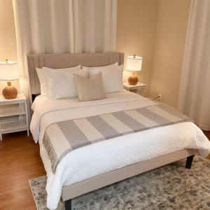 a bedroom with a large bed with two lamps at 3BR Pool Villa on Golf Course Huge Yard & Games in Wellington
