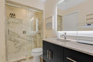 a bathroom with a shower and a sink and a toilet at 3BR Pool Villa on Golf Course Huge Yard & Games in Wellington