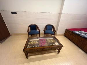 two chairs and a coffee table in a room at Hotel ranjeet in Alīgarh