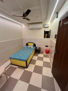 a bedroom with a bed in a room with a checkered floor at Hotel ranjeet in Alīgarh