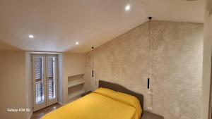 a bedroom with a yellow bed and a window at Casa Picicio in Assisi