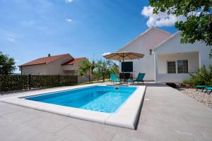 a swimming pool in front of a house at Villa Dalmatina in Vedrine