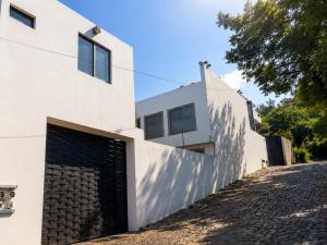 a white house with a black gate at Nuevos departamentos en Valle de Bravo in Valle de Bravo