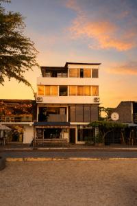 a tall white building with a sunset in the background at Plaza Lobos in Puerto Baquerizo Moreno