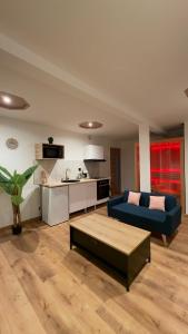 a living room with a blue couch and a kitchen at Sauna spa in Rouen
