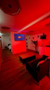 a red living room with a couch and a tv at Sauna spa in Rouen