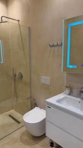 a bathroom with a toilet and a shower and a sink at Green Coast Pearl Suites Apartments Palase in Palasë +21 photos