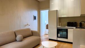 a living room with a couch and a kitchen at Green Coast Pearl Suites Apartments Palase in Palasë
