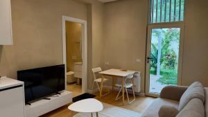 a living room with a couch and a tv and a table at Green Coast Pearl Suites Apartments Palase in Palasë