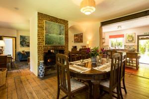 a dining room with a table and a fireplace at Westerlands Farm in Graffham