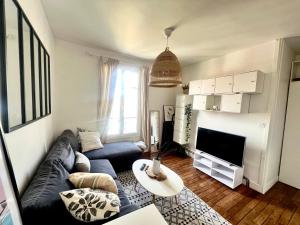 a living room with a couch and a tv at Superbe appartement- 10 min Paris- Metro in Maisons-Alfort