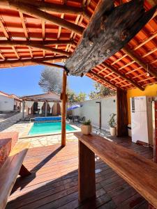 a wooden deck with a bench and a swimming pool at Chácara buriti in Pirenópolis