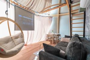 a living room with a couch and a projection screen at Glamp Zielone Skałki in Kluszkowce
