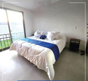a bedroom with a large bed with a large window at Nuevos departamentos en Valle de Bravo in Valle de Bravo +36 photos
