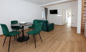a living room with a table and green chairs at Old town Bol apartments in Bol