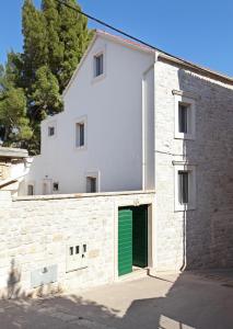 a white building with a green door at Old town Bol apartments in Bol