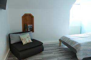 a bedroom with a chair next to a bed at Royal Racing Suite Top 5 near Red Bull Ring in Judenburg