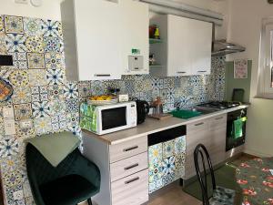 a kitchen with a counter with a microwave and a stove at Lake Apartment Ischia Green, Lago di Caldonazzo in Tenna 