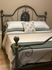 a bed with a metal frame and white sheets and pillows at Il Vialetto in Cannara