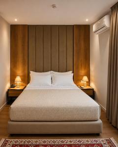 a bedroom with a large bed with two lamps on tables at 313 Villa City Center in Tirana +30 photos