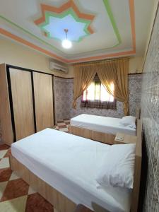a bedroom with two beds and a ceiling at Set in Taza
