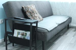 a couch with a side table with a remote control at Royal Racing Suite Top 6 near Red Bull Ring in Judenburg