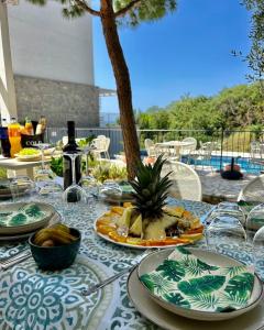 a table with plates of food and a pineapple on it at Mostoliva Sea View Studios in Pržno