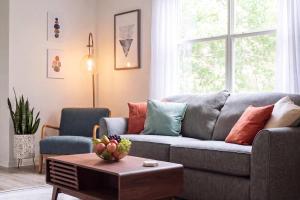 a living room with a gray couch and a table at Sanctuary at Oaks - Full Kitchen , Near I75 in Gainesville