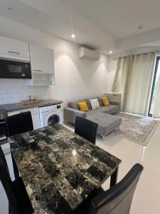 a kitchen and living room with a table and a couch at Bait Al Marina in Salalah