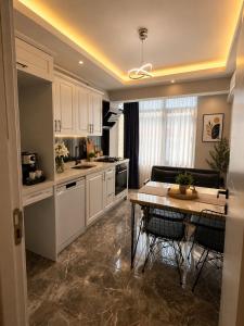 a kitchen with white cabinets and a table with chairs at Mahal house in Pelitli