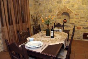 una mesa de comedor con una botella de vino. en Adam Villas, en Falasarna