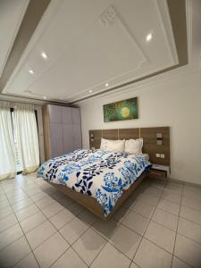 a bedroom with a bed with a blue and white comforter at Etienne Gae 2 in Douala