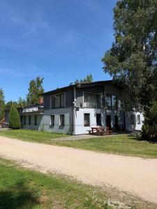 a large white building with a picnic table in front of it at Šķilas in Pērkone