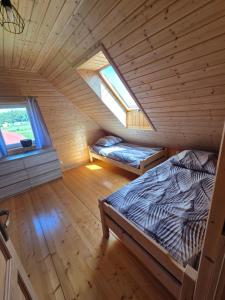 a bedroom with two beds in a wooden cabin at Łąkowe Zacisze - Kozin in Bogaczewo