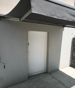 a garage with a white door and a roof at Suite DT4 in Blotzheim