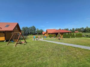 a yard with a playground and a house at Łąkowe Zacisze - Kozin in Bogaczewo
